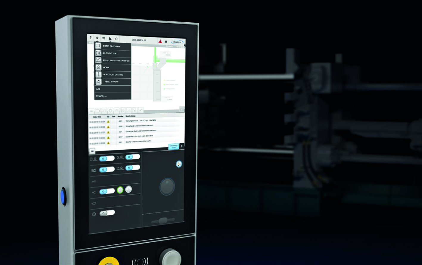 Dataview control unit touchscreen in the foreground and die casting machine in the background. 