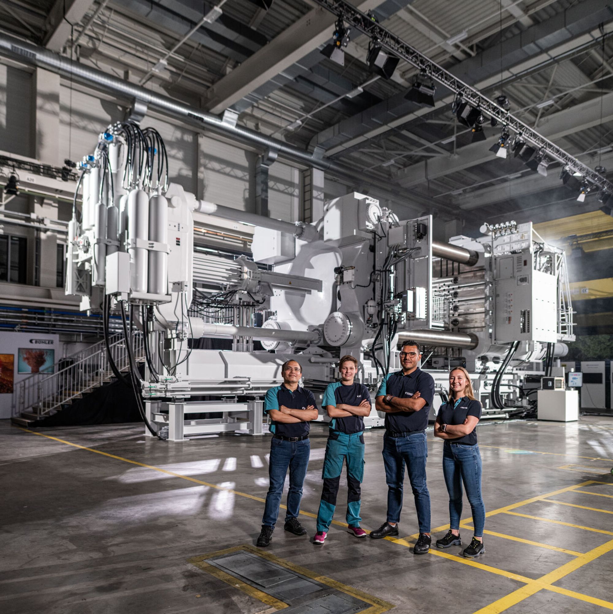 Carat die-casting machine with four employees in front