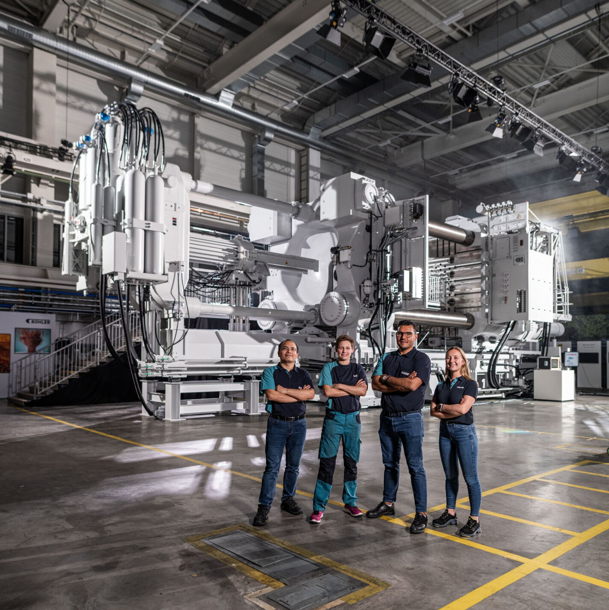 Carat die-casting machine with four employees in front