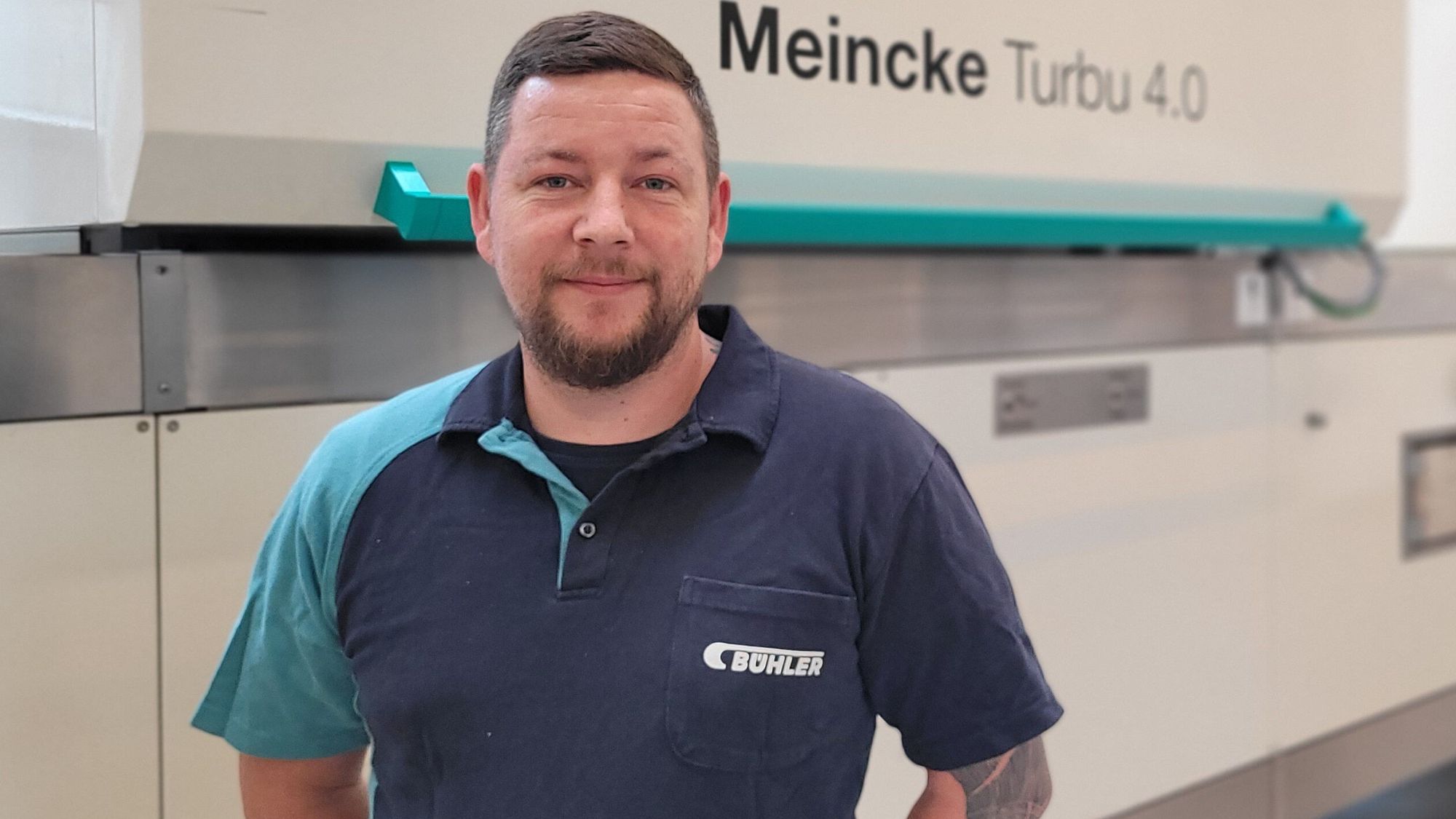 A Bühler employee standing in front of a cookie line.
