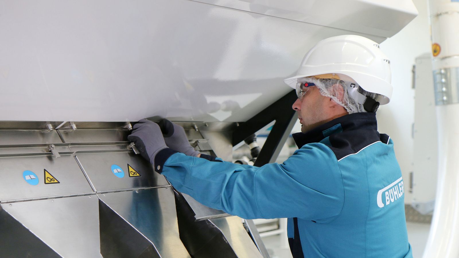 Bühler employee opening the chutes of an optical sorter SORTEX