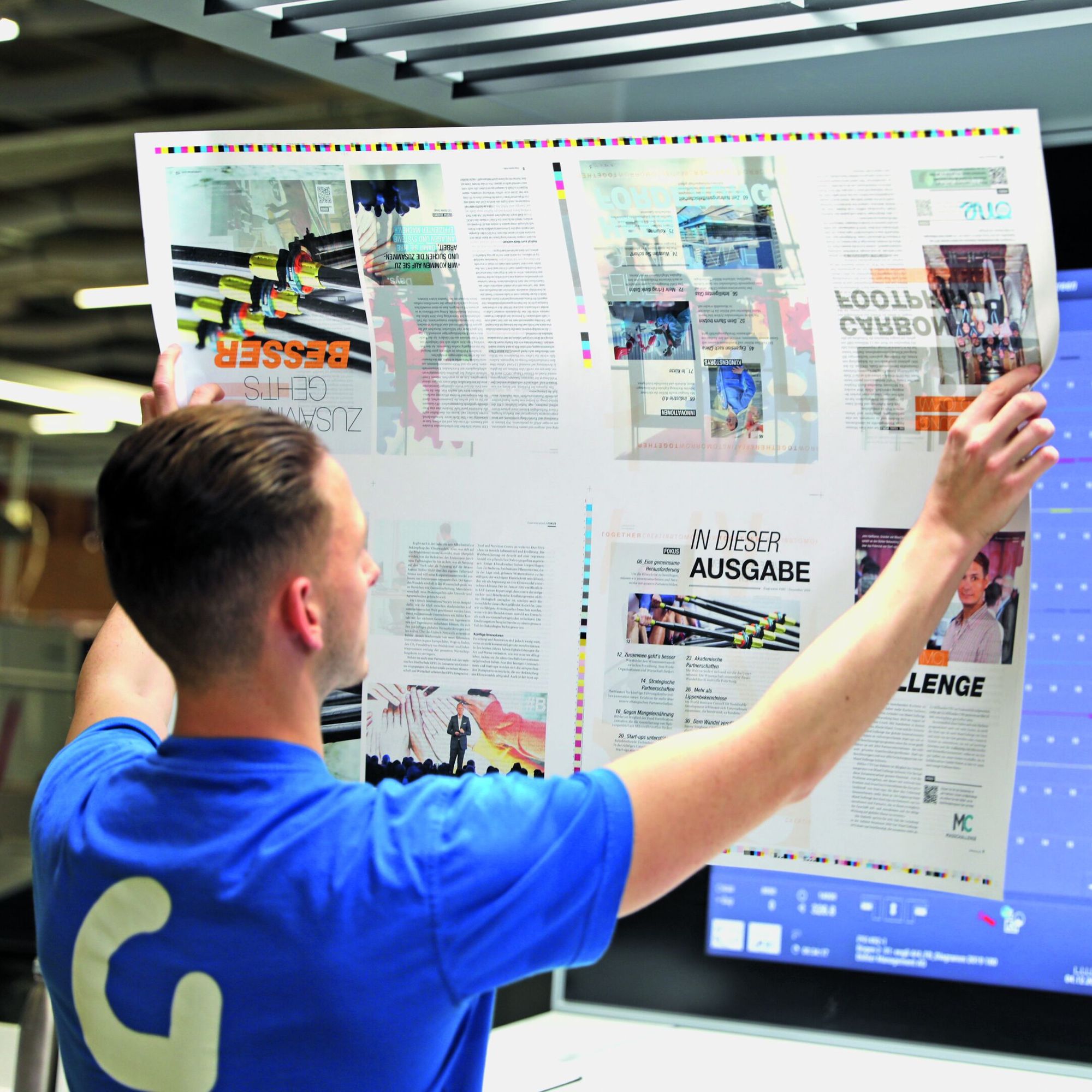 man looking at print out of magazine