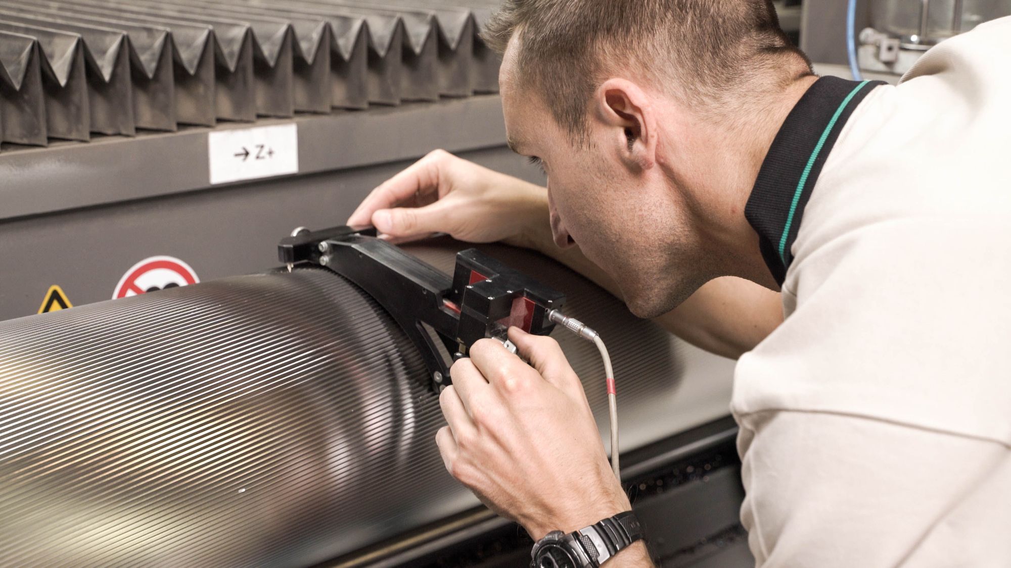 A technician measures a corrugated roll.
