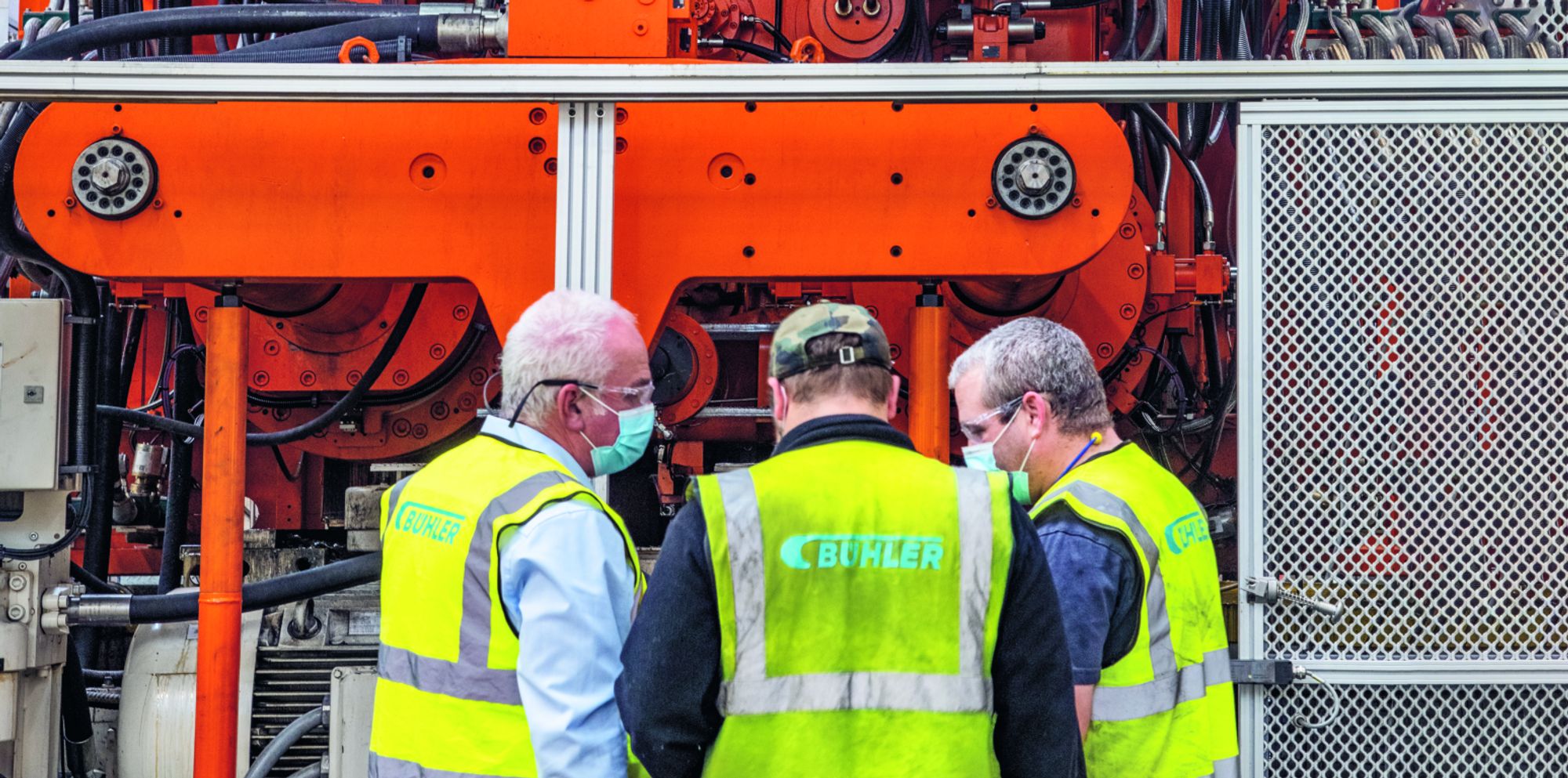 View of Carat die casting cell with 3 people standing in front of it