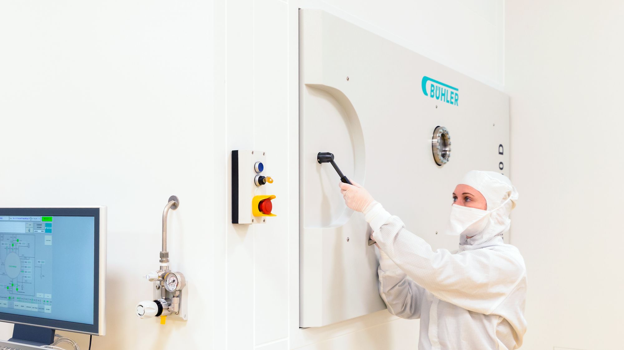 Tina Seifert, EUV coating specialist at optiX fab, transfers the substrate from the clean room through the load lock to the coating chamber of NESSY in the machine room. 