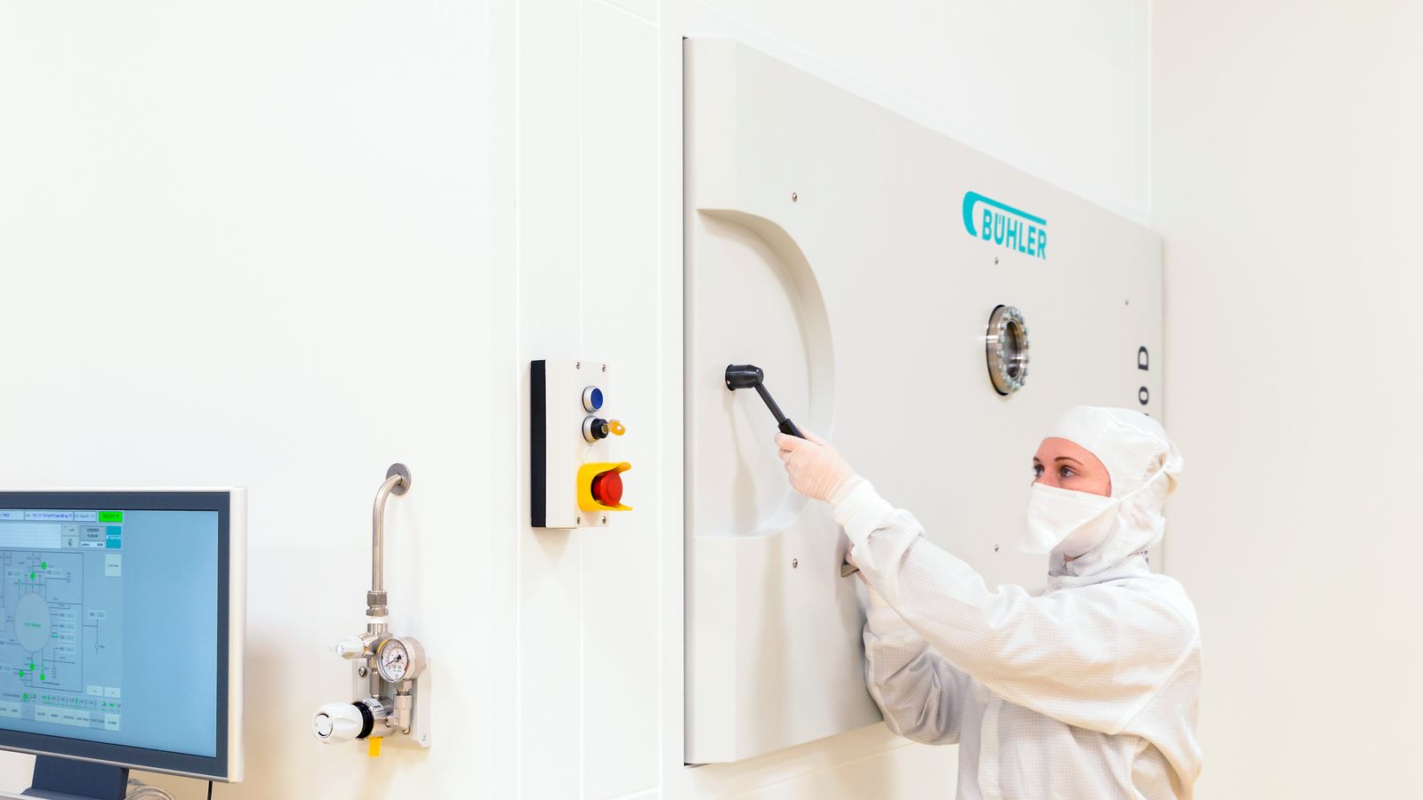 Tina Seifert, EUV coating specialist at optiX fab, transfers the substrate from the clean room through the load lock to the coating chamber of NESSY in the machine room. 